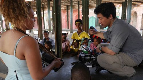 Kelley Kali directing a group of children with DP Xing Mai Deng in Haiti.