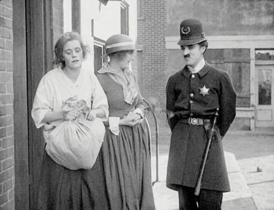 Charles Chaplin, Leota Bryan, and Edna Purviance in Easy Street (1917)